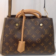 Load image into Gallery viewer, This Louis Vuitton  Vintage Monogram Montaigne BB is in the original monogram pattern and has camel handles.  Attached to the handles is  a camel leather strap  which has a leather key holder at the end. There is an attachable monogram leather shoulder strap included. The bag opens at the top, has a middle zippered pouch and the interior is a lovely shade of burgundy.
