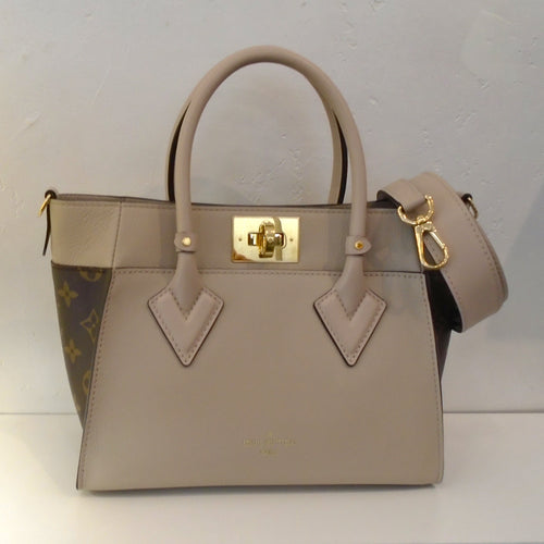 This Louis Vuitton Vintage Monogram/Bicolor On My Side PM has a beige front and back with original monogram pattern on the sides of the bag. It has double carrying handles with a detachable shoulder strap included. It also comes with the original Box and dust bag. The interior of this bag is soft gray.