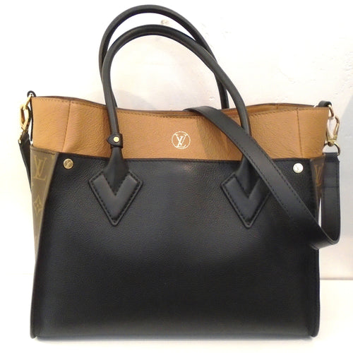 This Louis Vuitton Monogram/Black X Trion On My Side has camel trim which includes the top band across the bag. The sides of the bag are in the original monogram pattern. It has two carrying handles and a detachable shoulder strap is included. The interior of this bag is camel.