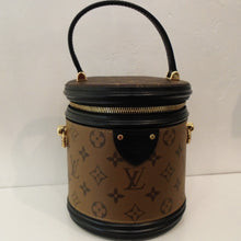 Load image into Gallery viewer, This Louis Vuitton Vintage Reverse Monogram Cannes PM With Leather Trim is camel with the large Louis Vuitton Monogram pattern. It is shaped like a bucket with a leather handle similar to a bucket handle. The top zips open around the top. The interior of this bag is black.
