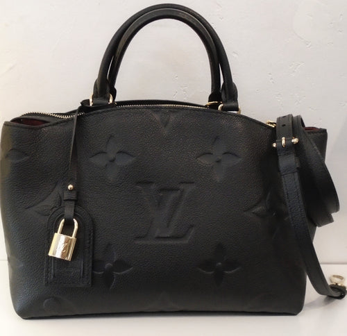This Louis Vuitton Vintage Empreinte Palais PM has the large monogram Empreinte pattern. The color of this bag is black with gold hardware and a red interior. It has a detachable shoulder strap.