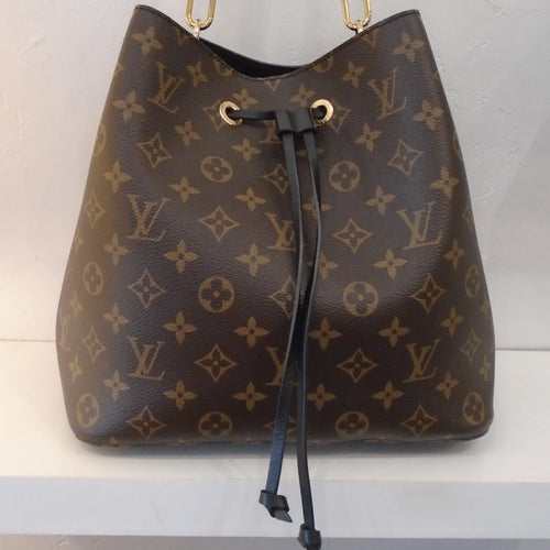 This Louis Vuitton Vintage Monogram/Black NeoNoe is in the original monogram colors and has black trim and gold hardware. The interior of the bag is black with a monogram zippered change purse in its center.