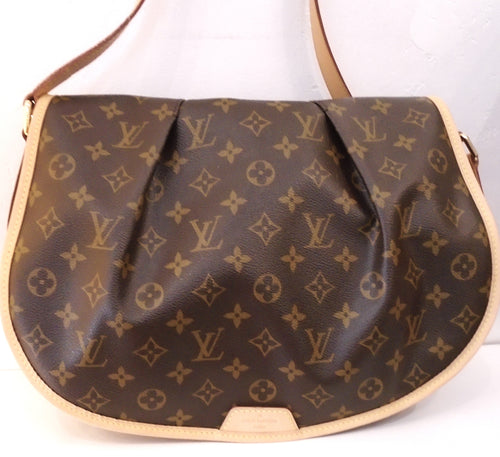 This Louis Vuitton Vintage Monogram Menilmontant MM has the original monogram pattern, camel trim and gold hardware. This bag has a plump full flap in the front of the bag. It has an adjustable shoulder strap and a zippered pocket on the outside back of the bag. The interior is a chocolate brown.