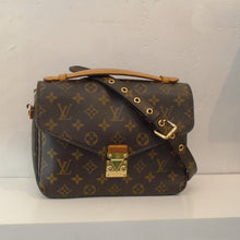 Load image into Gallery viewer, This Louis Vuitton Vintage Monogram Metis Pochette is in the original Louis Vuitton monogram pattern and color. It has camel trim and gold hardware. This bag has a carrying handle and an adjustable shoulder strap. The interior of the bag is also camel with several compartments.
