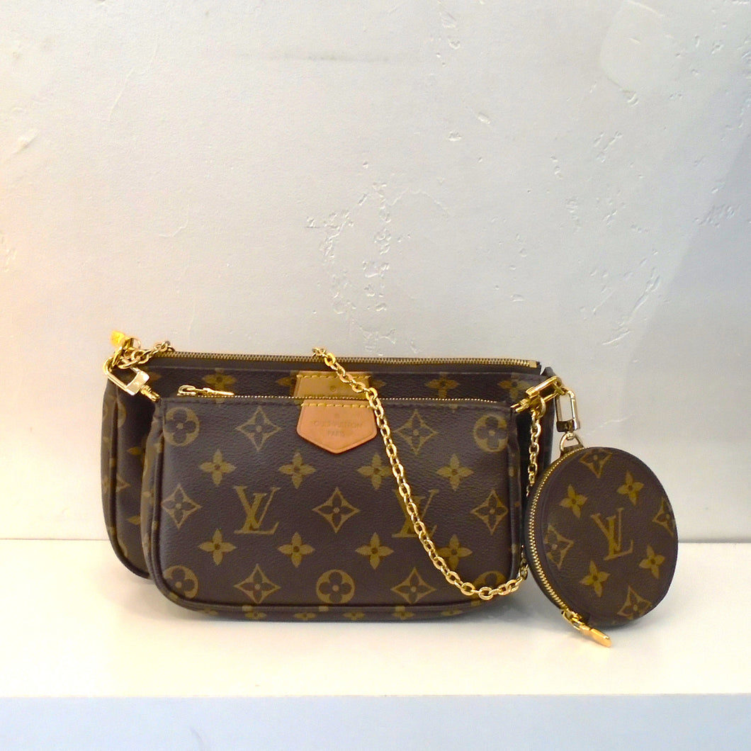 This Louis Vuitton Vintage Multi Pochette Accessoires Monogram comes with a detachable shoulder chain and a forest green Louis Vuitton Guitar Strap. This bag has camel trim and has two sections both with top zippers. It has a round zippered pochette attached to the side of the bag. The interior is a soft brown.