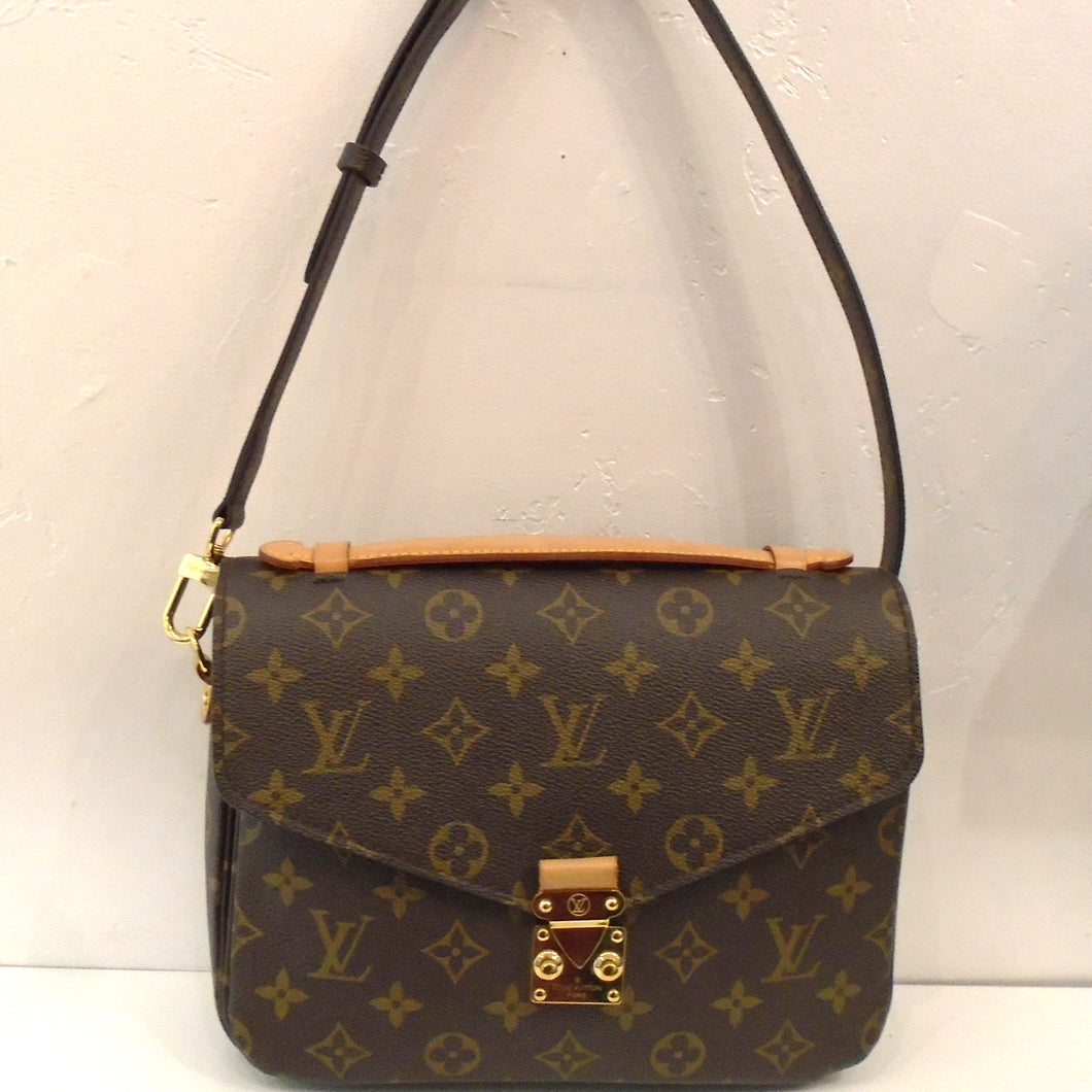 This Louis Vuitton Monogram Metis Pochette is in the traditional monogram style with a sturdy adjustable and removable strap. It has an interlocking snap front latch and a dark brown soft interior.