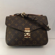 Load image into Gallery viewer, This Louis Vuitton Vintage Me'tis Pochette MM is in the original monogram pattern. It has gold hardware, camel trim and an outside back pocket. This bag has a carrying handle and a shoulder strap. The interior of the bag is in a dark brown color with two sections.
