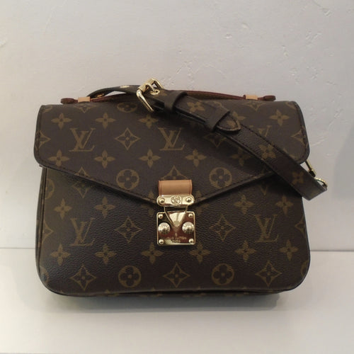 This Louis Vuitton Vintage Me'tis Pochette MM is in the original monogram pattern. It has gold hardware, camel trim and an outside back pocket. This bag has a carrying handle and a shoulder strap. The interior of the bag is in a dark brown color with two sections.