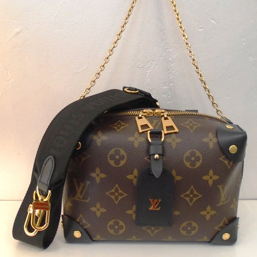 This Louis Vuitton Vintage Monogram Macassar Petite Malle Souple is in the original monogram pattern with corner protectors in black. It has a double headed zipper for the top opening. This bag has a  sturdy black carrying handle, a detachable gold shoulder chain and detachable guitar strap included. It has black trim and  a black interior.