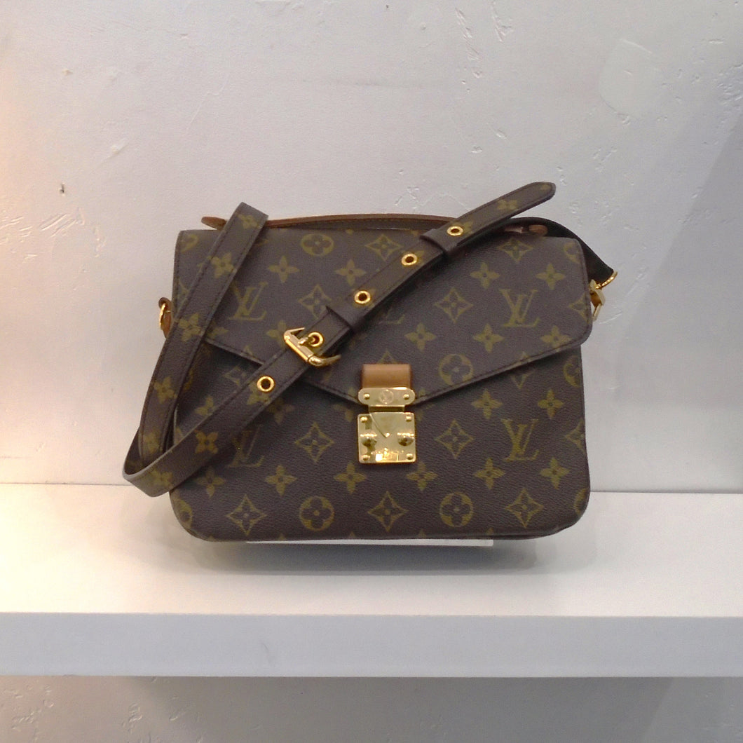 This Louis Vuitton Vintage Monogram M`etis Pochette has the original Louis Vuitton Monogram Pattern and gold hardware. It has a removable adjustable strap and a back outer zipper. The interior of this bag is soft dark brown.