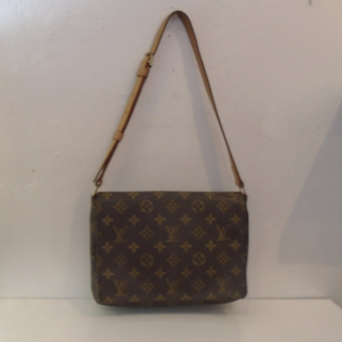 This Louis Vuitton Vintage Monogram Musette Tango is in the original Louis Vuitton Monogram pattern.  It has camel trim, a shoulder strap and the interior of this bag is brown.