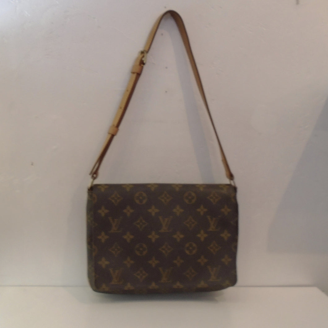 This Louis Vuitton Vintage Monogram Musette Tango is in the original Louis Vuitton Monogram pattern.  It has camel trim, a shoulder strap and the interior of this bag is brown.