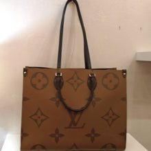 Load image into Gallery viewer, This Louis Vuitton Vintage Monogram On The Go GM Reverse  is camel monogram on one side and dark brown monogram on the other. Each side is also camel monogram on one side and dark brown monogram on the other. The monogram on this bag is the large style on the front and back. The sides are in the regular size monogram style. It has gold hardware and a pink interior.
