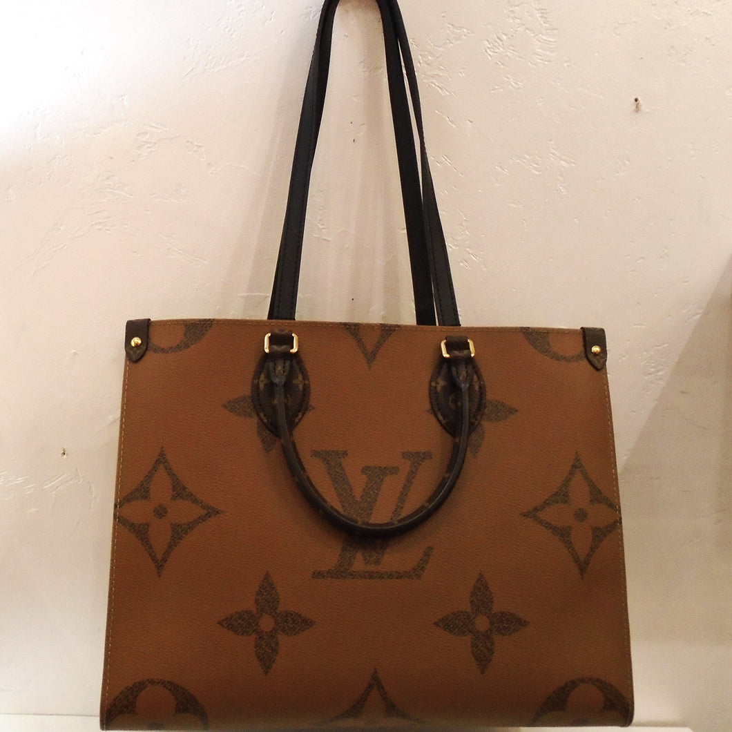 This Louis Vuitton Vintage Monogram On The Go MM Reverse has 4 sides. This bag has the large monogrram pattern with one side dark brown and the other a lighter brown. The sides are in smaller monogram but also have one light brown and the other dark brown. It has gold hardware and dark brown trim. The bag has double shoulder straps and double handles. The interior of this bag is red.