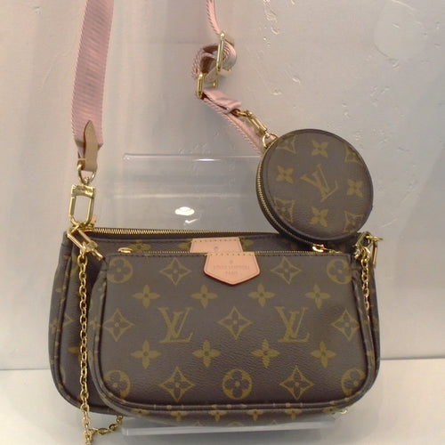 This Louis Vuitton Vintage Monogram Pochette-Accessoires is a shoulder bag made of three pochettes, a pink detachable Louis Vuitton guitar strap and a round zippered change purse. It also has a detachable shoulder chain. The interior of the bag is a soft brown.