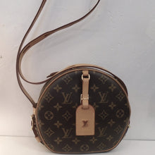 Load image into Gallery viewer, This Louis Vuitton Vintage Monogram Petite Boite Chapeou is round in the original monogram pattern. It has a key holder in camel leather attached to the front. This bag has a zippered top opening and gold hardware. It has a camel back pocket , camel shoulder strap and the interior is light brown.
