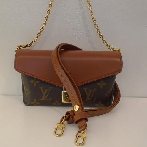 This Louis Vuitton Vintage Monogram Padlock On Strap has a padlock on the front flap. It has a detachable shoulder chain and a detachable shoulder strap. The bag comes to a point on the bottom and will not sit flat.