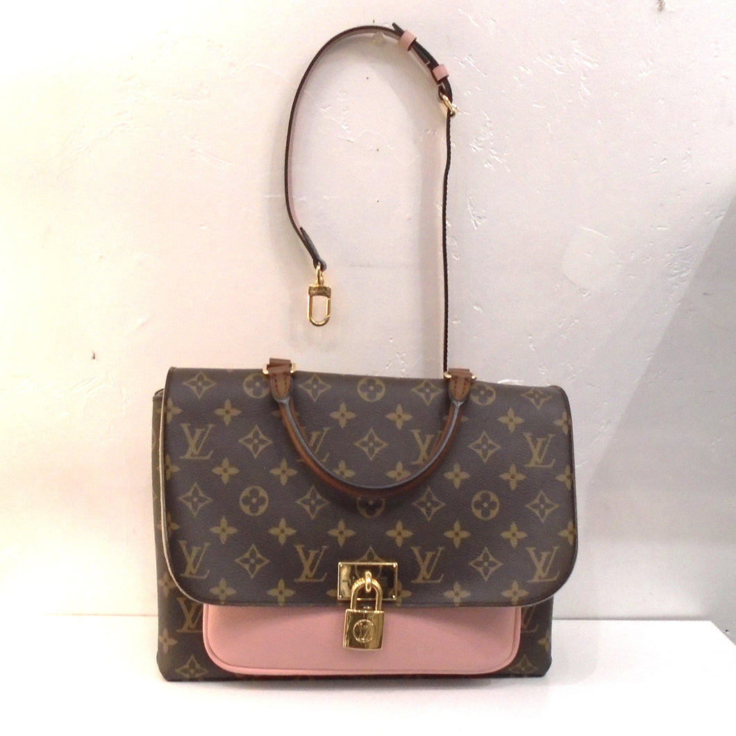 This Louis Vuitton Vintage Monogram/Pink Marignan has a pink pouch between the front flap and body of the bag. It has a brown top carrying handle with a detachable adjustable shoulder strap included. The front gold clasp has the appearance of a small lock. The interior of this bag is a beige color.