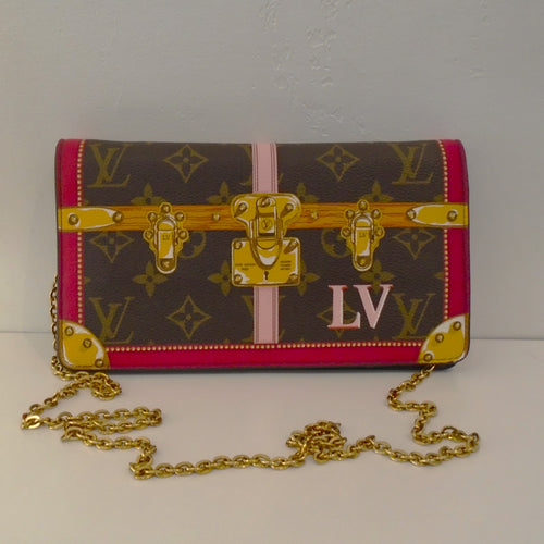 This Louis Vuitton Monogram Pochette Weekend has the appearance of a steamer trunk. It has a detachable chain so it can be used as a shoulder bag or clutch.