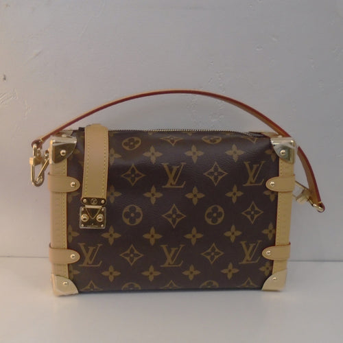 This Louis Vuitton Vintage Monogram Side Trunk is a handbag that resembles a Louis Vuitton steamer trunk. It is in the original monogram pattern with camel trim. It comes with a top strap and adjustable shoulder strap. The interior of this bag is a soft brown.