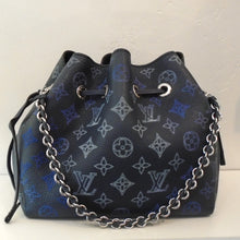 Load image into Gallery viewer, This Louis Vuitton Vintage Navy Bella Bucket Bag has a navy leather draw string and a silver shoulder chain that has a navy leather strip woven between the chain. It is in the large original Louis Vuitton monogram pattern and the interior is navy also.
