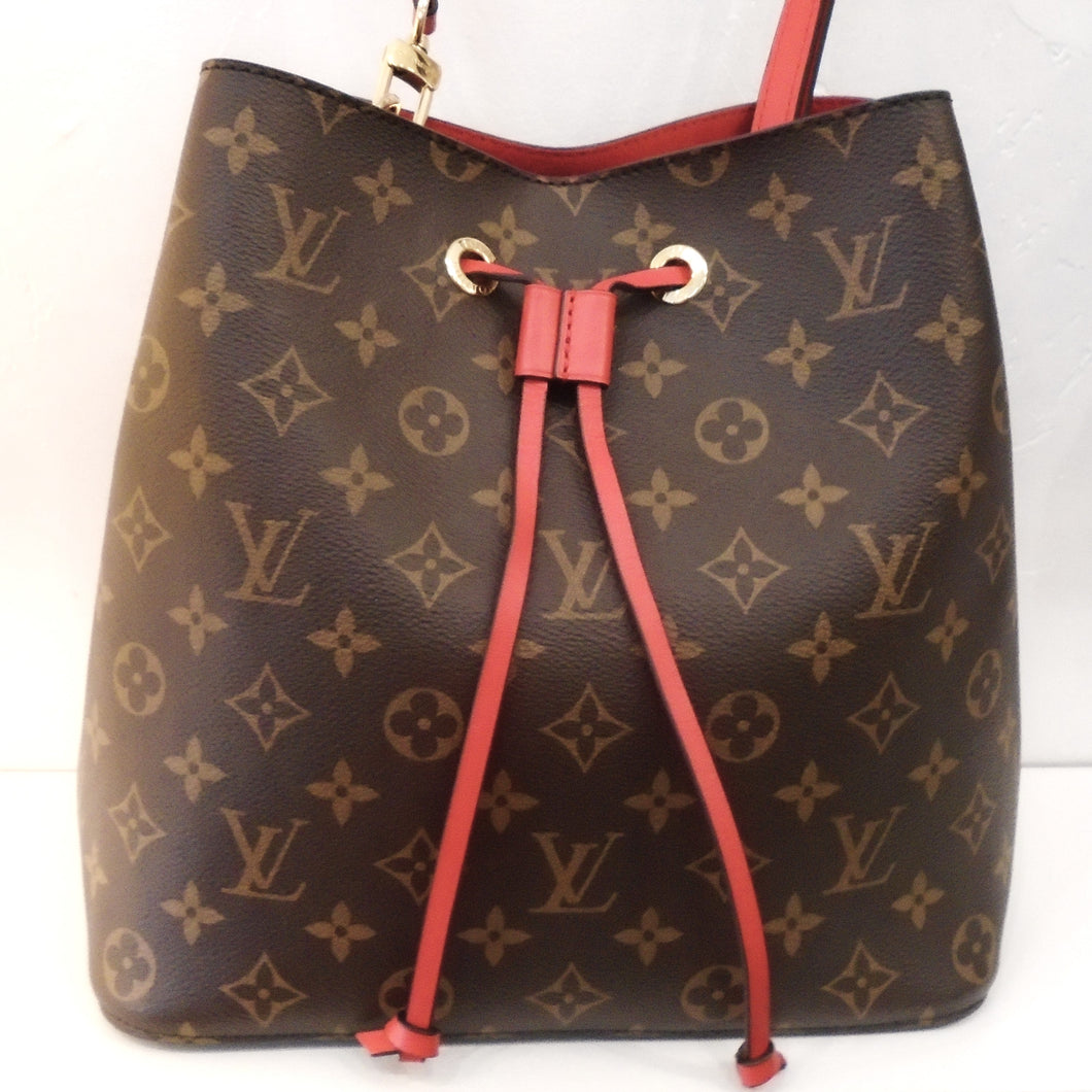 This Louis Vuitton Vintage Monogram Neo Noe has the original Louis Vuitton Monogram pattern with a red leather draw string and a red adjustable shoulder strap. The interior of the bag is red and it has a middle zippered pocket.