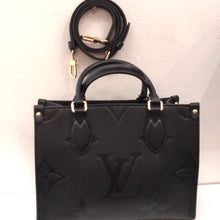 Load image into Gallery viewer, This Louis Vuitton Vintage Black On The Go PM has the large Monogram style in Empreinte Leather. It has gold hardware and  double carrying handles. This bag also includes a detachable leather shoulder strap. The interior of this bag is black.
