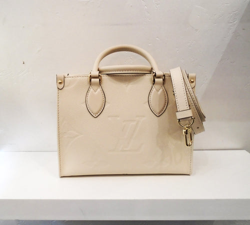 This Louis Vuitton Vintage On The Go Vanilla PM is in the large monogram empreinte leather pattern. It has two carring handles and has an adjustable shoulder strap included. The interior of the bag is in the same vanilla shade.