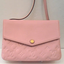 Load image into Gallery viewer, This Louis Vuitton Vintage Pink Empreinte Leather Twice is a lovely shade of soft pink. The body of the bag is Imprinted with the Louis Vuitton monogram but the front flap and strap are smooth. The interior of this bag is a lighter shade of pink. The front V shaped flap simply snaps together with a gold snap.
