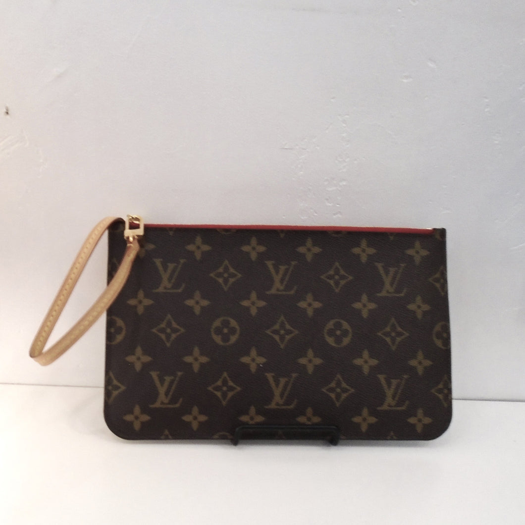 This Louis Vuitton Vintage Pochette Pouch is in the original monogram pattern with camel trim. It has a top zipper with a leather loop attached to it. The interior of this pouch is red with black stripes.