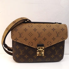 Load image into Gallery viewer, This Louis Vuitton Vintage Reversible Monogram Metis MM is a two tone bag. It has light brown background with darker brown monogram from the back to the front flap. It has dark brown background with light brown logo on the body of the bag. The shoulder strap is the same with the light brown and dark brown monogram on the outer side. This bag has gold hardware and the inside of the bag has two sections.
