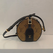 Load image into Gallery viewer, This Louis Vuitton Vintage Reverse Monogram Mini Boite is a round bag with the large Louis Vuitton Monogram and zipper opening. It has a shoulder strap and gold hardware. The interior of this bag is light brown with a diamond design on the other side.
