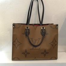 Load image into Gallery viewer, This Louis Vuitton Vintage Reverse Monogram On The Go MM has the Louis Vuitton monogram pattern enlarged on both the front and back of the bag. One side has a light brown background and dark monogram whereas the other side has dark brown background with light monogram. The two sides have the same with smaller monogram.  It has double shoulder straps along with double carrying handles. The interior of this bag is red.
