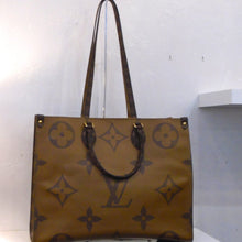 Load image into Gallery viewer, This Louis Vuitton Vintage Reverse On The Go GM has four separate sides that rotate the light background with dark monogram to dark monogram with light background. It has double carring handles and double shoulder straps. The interior is red.
