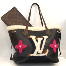 Load image into Gallery viewer, This Louis Vuitton Vintage Teddy Neverfull MM is made of black leather and white shearling Trim. It has a large Louis Vuitton Logo in white and blue shearling with two pink shearling flowers on either side. A monogram pouch is included with this bag. The interior is a soft red.
