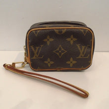 Load image into Gallery viewer, This Louis Vuitton Trousse Wapity Wristlet is small enough to fit in your hand. It has camel trim which includes the wrist loop. The pattern on this Wristlet is in the original large monogram. The interior of this Wristlet is red.
