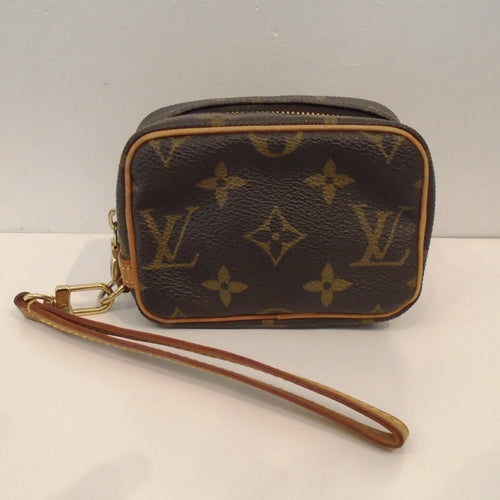 This Louis Vuitton Trousse Wapity Wristlet is small enough to fit in your hand. It has camel trim which includes the wrist loop. The pattern on this Wristlet is in the original large monogram. The interior of this Wristlet is red.