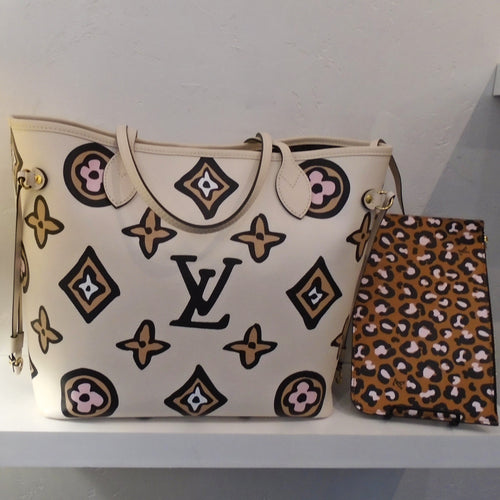 This Louis Vuitton Vintage Wild At Heart Neverfull MM Empreinte Leather With Pochette includes a Neverfull bag that has an Ivory background with white, tan and pink large monogram pattern. The pochette is a cougar design with brown background. The interior of this bag is a gray cougar design.