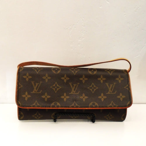 This Louis Vuitton Vintage Monogram Wallet Pochette has camel trim and a long shoulder strap that can worn as crossbody or tucked inside the bag to carry as a clutch. The interior of this bag is a soft cream color.