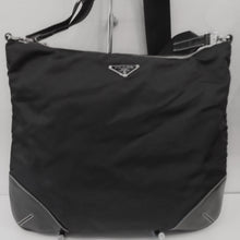 Load image into Gallery viewer, This Prada Vintage Large Nylon Top Zip Messenger has silver hardware and leather corner reinforcements. It has an adjustable canvas shoulder strap. The interior of the bag is black with Prada written in silver on the inside of the bag.
