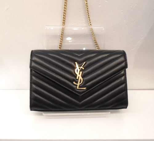 This YSL Cassandre WOC is black and Y quilted and has the YSL Logo on the front lip of the bag. It has gold trim along with a gold shoulder chain. This bag comes with it's original box and was never carried. The interior is black, has a zippered compartment and plenty of card pockets.
