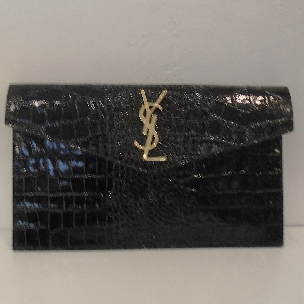 This  YSL Crocodile Embossed Uptown Clutch is black with gold hardware.