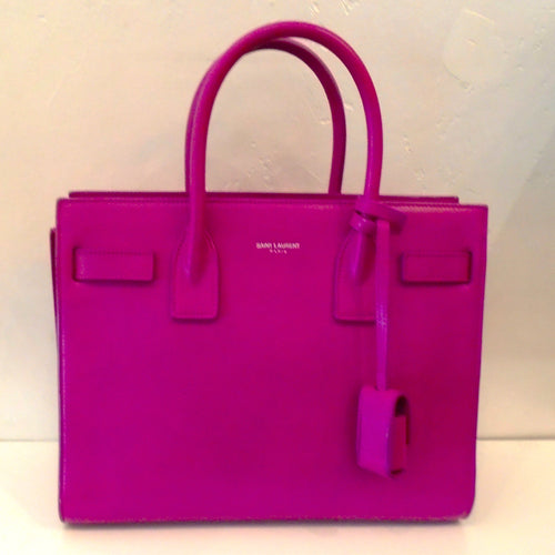 This YSL Fuchsia Sac De Jour has two carrying handles and accordian sides to help expand the top opening for easy access. The interior of this bag is black which really complements the Fuchsia color of the bag.