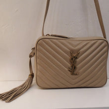 Load image into Gallery viewer, This YSL Taupe Lou Medium Crossbody Chevron Camera Bag has dark gold hardware which works well with the taupe color. It has a tassle attached to the side of the bag. This bag has a top zipper and a pocket on the interior.

