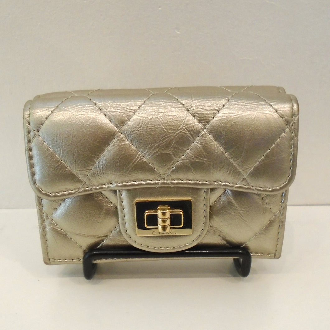 This is a small hand held gold tone wallet with diamond design stitching. It has a gold clasp on the front and opens up to hold essentials.