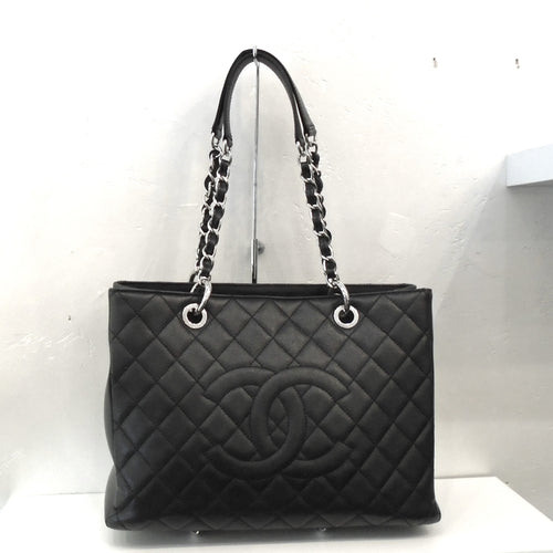 This Chanel Vintage Black Caviar Leather GST has the Chanel CCs stitched on the front of the diamond stitched bag. It has double silver chain straps with a black leather strip running through the links and shoulder guards on each chain. The back of the bag has a large pocket.