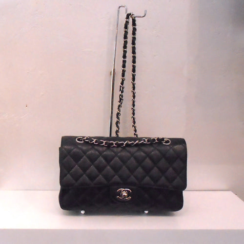 This Chanel Vintage Black Medium Double Flap has silver hardware and the silver shoulder chain has a black leather strip interwoven between the chain links.