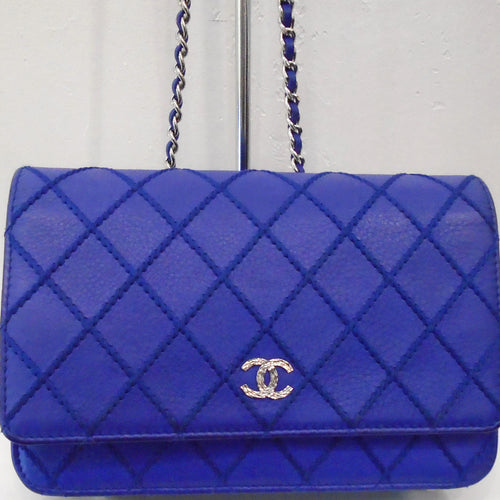 Tlhis Chanel Vintage Caviar Leather WOC is Colbalt Blue with silver hardware. The double C logo is silver with clear stones which give it a sparkle within the stitched diamond pattern. The silver shoulder strap has a cobalt Blue leather strip threaded through the chain links.