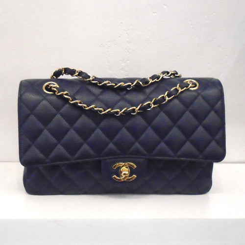This Chanel Vintage Double Flap Medium Bag  is in Navy Caviar Leather and comes with the original box. It has a gold clasp and gold chain with navy leather strip woven through it. There is a pocket on the outside back of the bag.