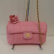 Load image into Gallery viewer, This Chanel Vintage Limited Edition Pink Lambskin Chocolate Bar Flap is pink with a square stitch pattern. It has a pink leather rose attached to the top of the flap on the left side. It has a gold shoulder chain with a pink leather strip through it and gold Chanel CCs on the leather snap.
